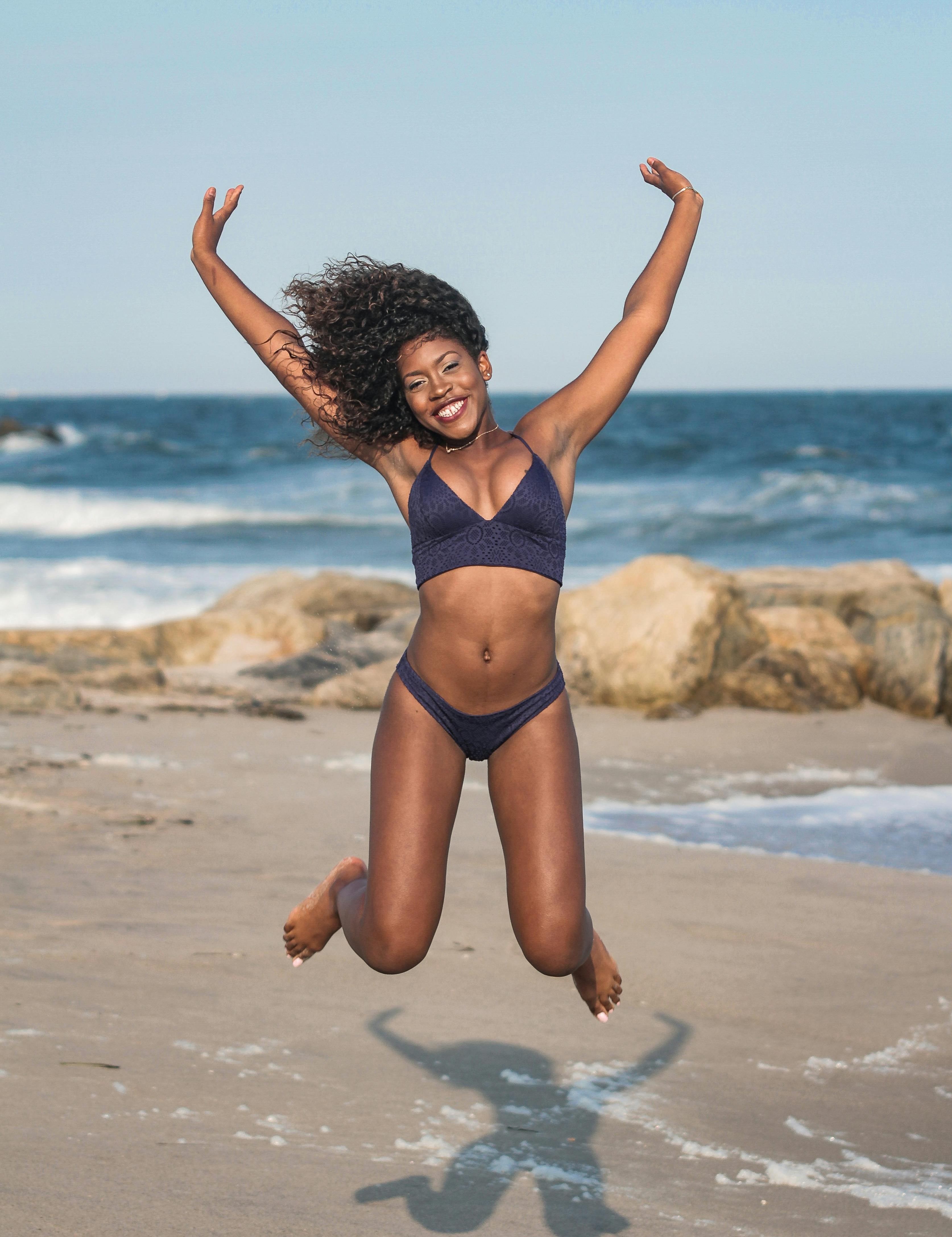 A woman playing at the beach with with period swimwear